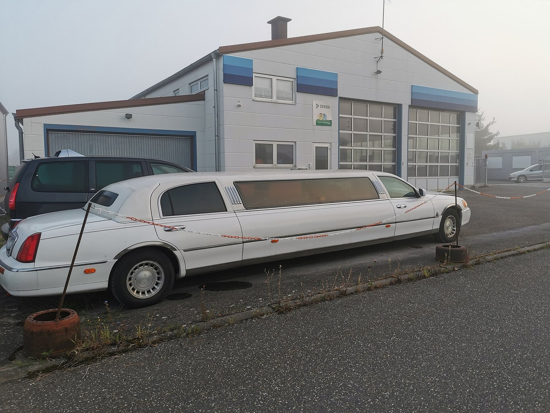 White stretch limousine beside a workshop